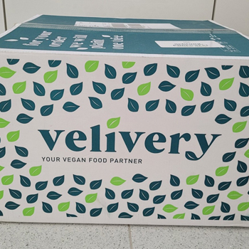 Velivery-Versandkarton mit dem Velivery-Logo und dem Slogan "Your Vegan Food Partner"